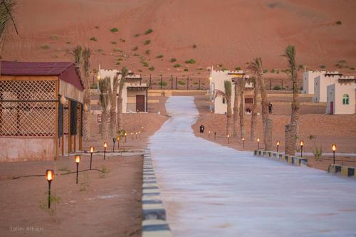 BadīyahAl Salam Desert Camp Bidiya的沙漠中一条有灯光的街道