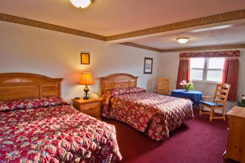 斯托宁顿美洲最佳价值客栈 - 斯托宁顿 的酒店客房设有两张床和一张桌子。