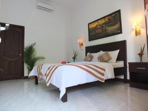 吉利特拉旺安瑞赛尔民宿的卧室配有一张床,墙上挂有绘画作品