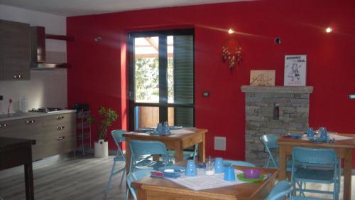SparoneB&B Valle Orco的厨房设有红色的墙壁和桌椅
