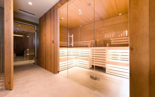 豪尔兹高Posthotel Lechtal的一间设有木墙和玻璃墙的桑拿浴室