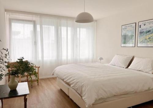 苏黎世Urban Oasis - 2BR Apartment near Bahnhof Zürich Oerlikon -302-的白色卧室配有一张大床和一张桌子