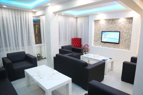 安塔利亚Konyaaltı HOTEL的一间设有椅子和墙上电视的等候室