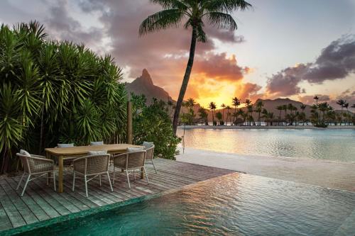 波拉波拉Westin Bora Bora Resort & Spa的池畔的桌椅,享有日落美景