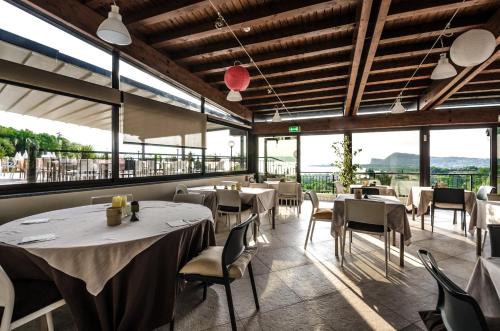 马内尔巴贝尔韦代雷酒店的餐厅设有桌椅和大窗户。