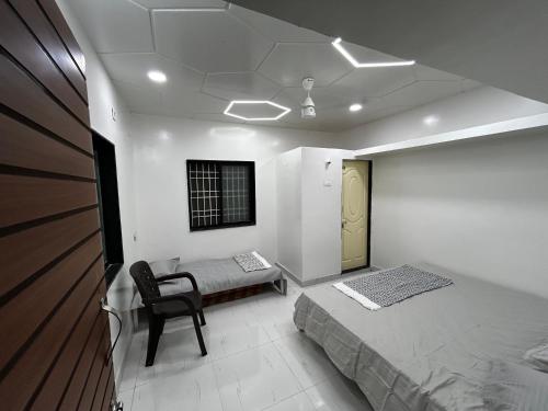 AkalkotVatavriksha Guest House,Akkalkot的一间卧室配有一张床和一把椅子