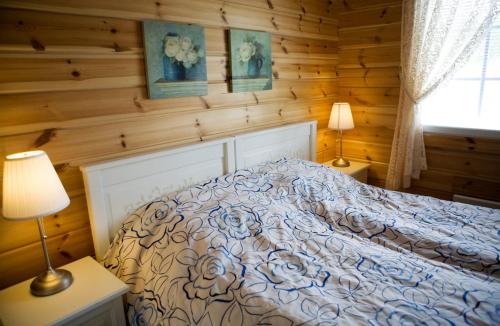 Längelmäki萨尔哥拉蒂度假宾馆的卧室配有木墙内的一张床