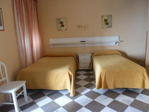 卡莫纳Hotel San Pedro的一张位于带 ⁇ 形地板的客房内的两张床