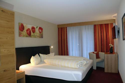 奥伯林塔尔的里德泽尔泽公寓的酒店客房,配有白色的床和椅子