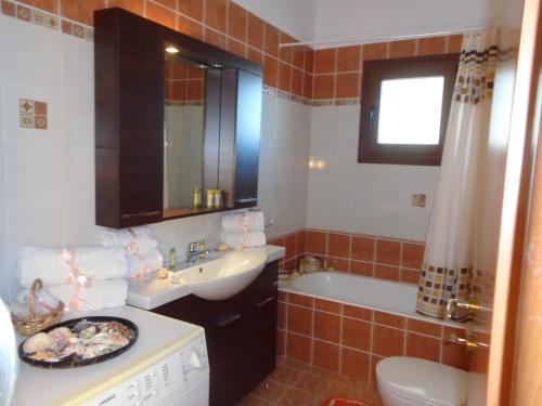 拉卡尼亚奇基别墅的浴室配有盥洗盆和浴缸。