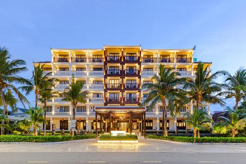 会安Wyndham Garden Hoi An Cua Dai Beach的一座棕榈树环绕的大建筑