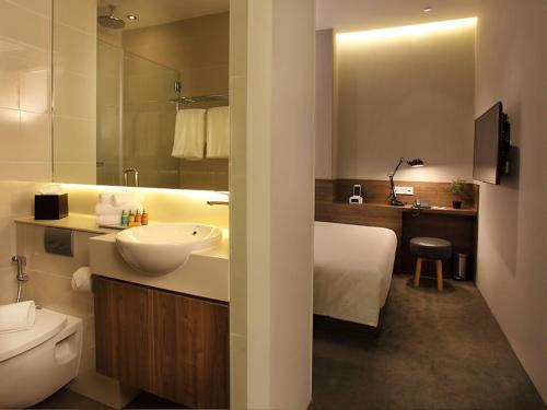 新加坡Arcadia Hotel的浴室配有白色水槽和卫生间。