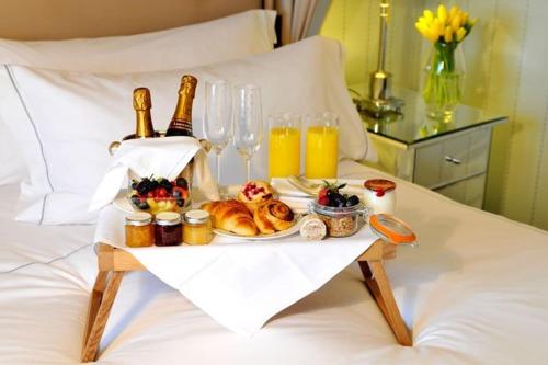 阿默达拉-伊拉克利翁厄里尼宫酒店的床上的食品和饮料托盘
