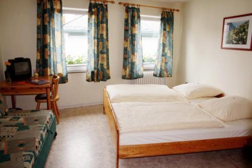 博帕德贝迪尼杰晨酒店的卧室配有一张床、一张书桌和窗户。