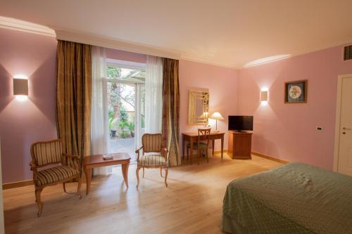 罗马阿特内奥花园皇宫酒店的一间卧室配有一张床、一张书桌和一个窗户。