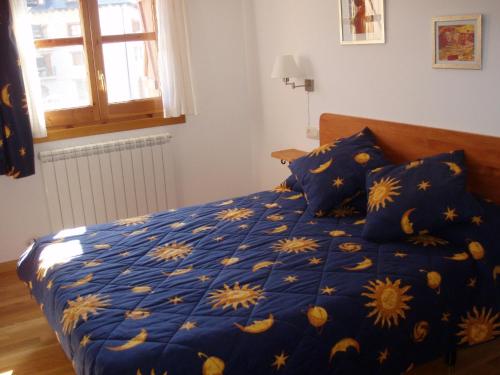 贝纳斯克Apartamento Lamatriz Dequin Edificio Sayo 8的一张带黄色鲜花的蓝色棉被的床