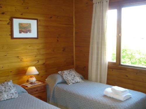 埃尔卡拉法特卢卡胡厄旅馆的一间卧室设有两张单人床和一个窗户。