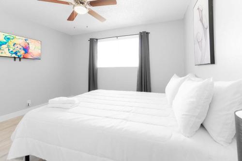 拉斯维加斯Chic 2-Bed Oasis Sleeps 6 Minutes From Strip的卧室配有白色的床和吊扇