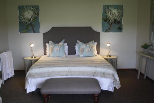 安德伯格Elgin Guest House的一间卧室配有一张带两张桌子和两盏灯的床。