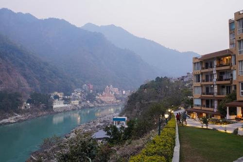 瑞诗凯诗Luxury Aloha Apartments, Rishikesh的享有河流、建筑和城市的景色