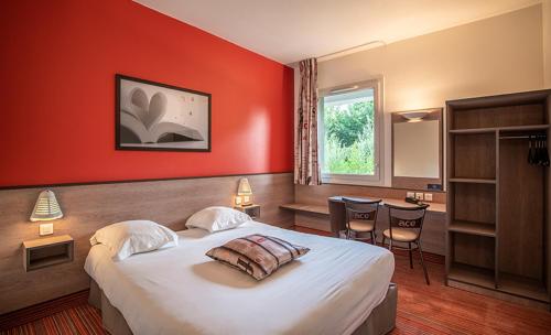 DéolsAce Hotel Chateauroux Déols的一间卧室设有一张红色墙壁的大床