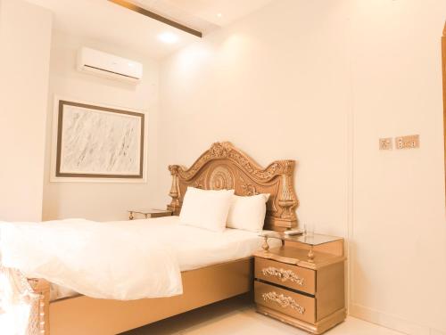 卡拉奇Stay Inn Hotel Rooms Karachi - Gulshan - Agha Khan Hospital - Airport的一间卧室配有一张带木制床头板的床