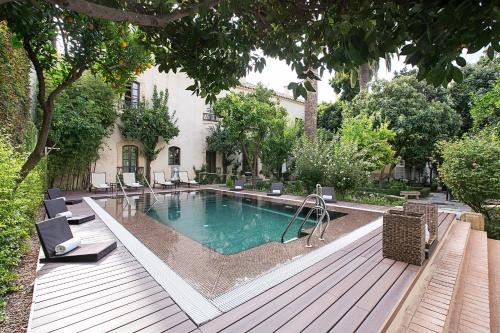 科尔多瓦柏丽奥宫酒店的房屋旁甲板上的游泳池