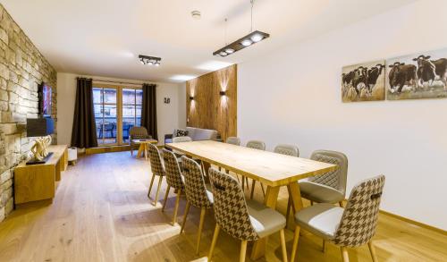 萨尔巴赫Bolodges Apartments by Alpin Rentals的一间带木桌和椅子的用餐室