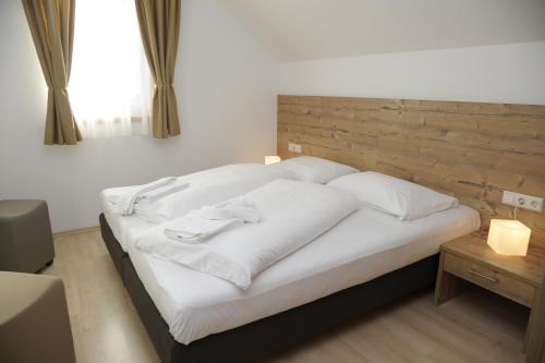 毛特恩多夫Haus Stella的卧室配有白色的床和木制床头板