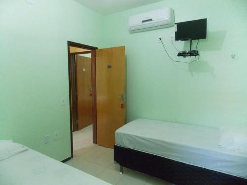 北茹阿泽鲁Pousada Cariri的卧室配有一张床,墙上设有篮球架
