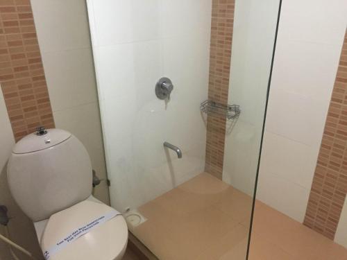 艾哈迈达巴德白金酒店的一间带卫生间和玻璃淋浴间的浴室