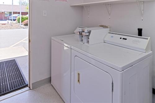 克拉马斯福尔斯豪华套房酒店的白色洗衣房配有洗衣机和烘干机