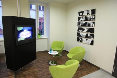 凯撒斯劳滕劳特巴赫艺术酒店的一间设有绿色椅子的房间和客房内的电视