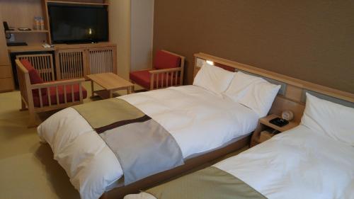 境港市御宿町诺诺酒店的酒店客房设有两张床和电视。