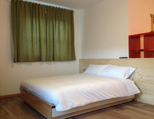 瓦尔迪登特罗SoleLuna的卧室内的一张床位,设有绿色窗户