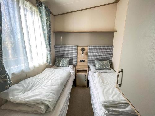 亨斯坦顿Beautiful Caravan At Manor Park Nearby Hunstanton Beach Ref 23030W的小型客房 - 带2张床和窗户