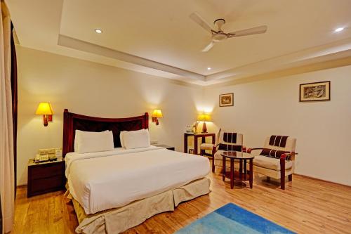 新德里Hotel Tej View Near Delhi Airport的卧室配有一张床和一张桌子及椅子