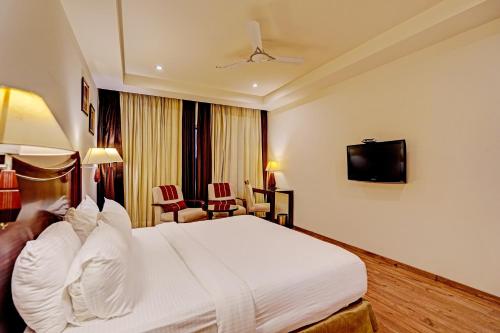 新德里Hotel Tej View Near Delhi Airport的酒店客房,配有床和电视