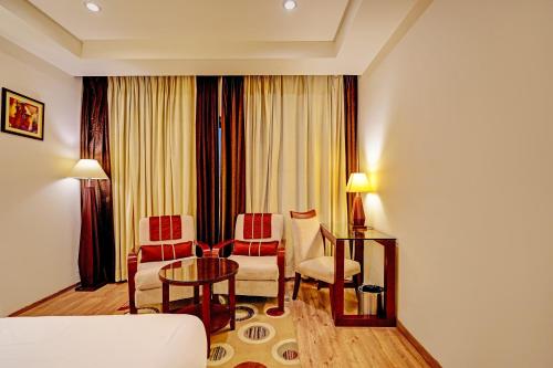 新德里Hotel Tej View Near Delhi Airport的酒店客房配有沙发和桌椅