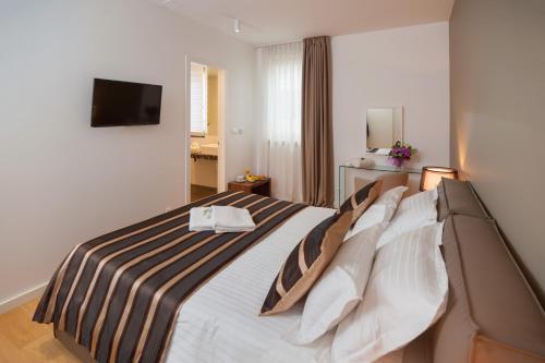 斯普利特维斯特碧尔宫住宅酒店的酒店客房,配有带条纹毯子的床