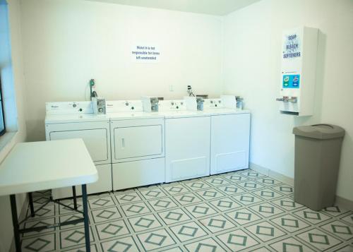 帕勒斯坦Motel 6-Palestine, TX的白色的浴室设有三个盥洗盆和一张桌子