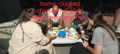 比卡内尔Karina art Home stay的一群坐在桌子旁吃食物的人