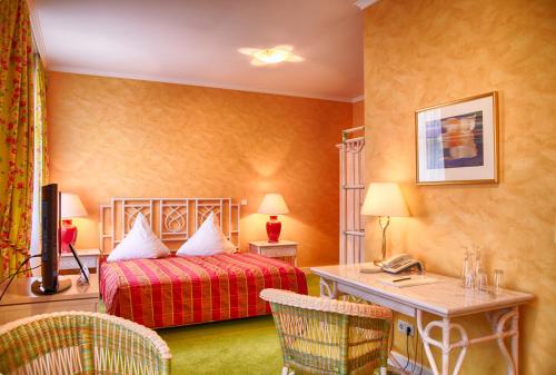伊瑟隆校园花园商务酒店 的配有一张床和一张书桌的酒店客房