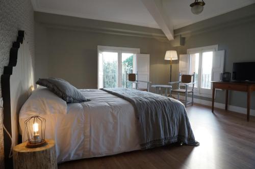 San Antonio de VilamajorHotel Can Ribalta的一间卧室配有一张大床、一盏灯和一张桌子