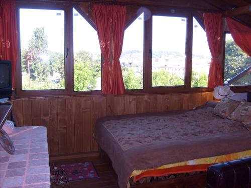 克卢日-纳波卡特兰西瓦尼亚牛仔小屋乡村民宿的一间卧室配有带窗户的床和电视。