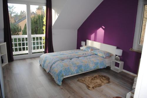 科隆多纳别墅的一间卧室设有紫色的墙壁和一张地毯。