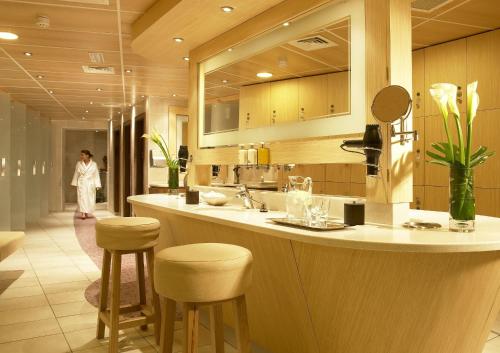 克洛纳基尔蒂因其多尼岛Spa酒店的厨房配有带凳子的柜台,厨房的背景是一位女性
