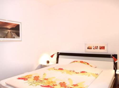 瓦尔内明德Ferienwohnung Warnemünde L (S2)的卧室配有一张白色床,墙上挂着一幅画