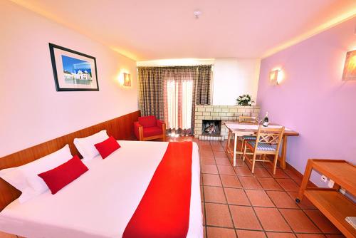 科武港Hotel Apartamento Porto Covo的一间卧室配有一张床、一张桌子和一个壁炉