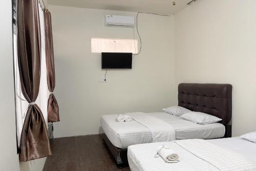 武吉丁宜OYO 94343 Mantari Guesthouse的客房设有两张床和窗户。